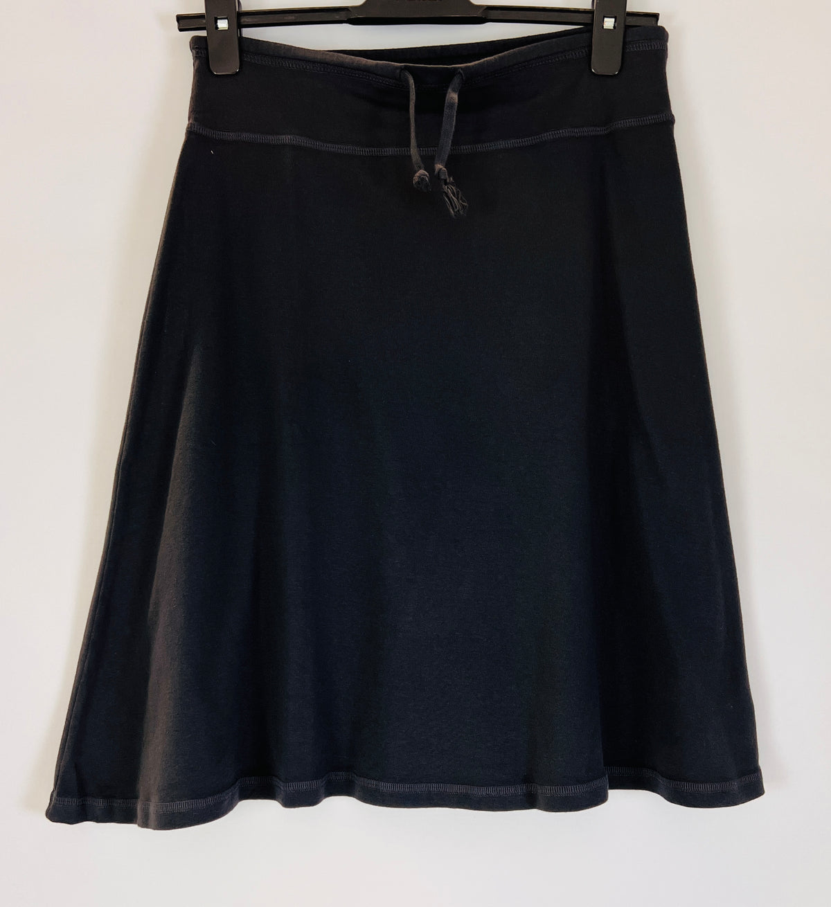 Black Cotton pull-on stretch skirt with adjustable drawstring tie waist and soft A-Line silhouette.