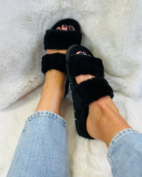 Slip on, two strap black faux fur fluffy sliders with an ergonomic black microsuede innersole
