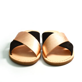 black suede and rose gold metallic straps on a flat crossover slide sandals
