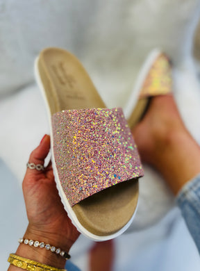Slip on, peachy pink sparkly sliders with an ergonomic microsuede innersole