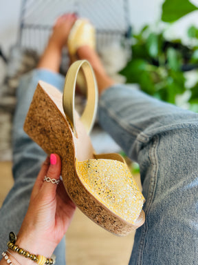 Bright sunshine golden yellow glitter uppers on an 8cm mid height lightweight cork wedge with gold leather slingback heel strap