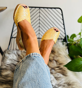 Bright sunshine golden yellow glitter uppers on an 8cm mid height lightweight cork wedge with gold leather slingback heel strap